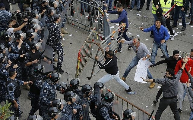 Lebanese anti-government protesters clash with riot policemen as they try to reach the government building in central Beirut, Lebanon, Dec. 23, 2018 (AP Photo/Bilal Hussein)