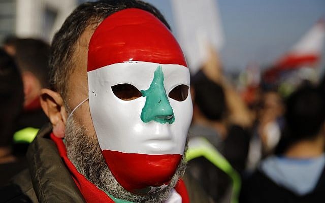 An anti-government protester wears mask mimicking the Lebanese flag during a protest in downtown Beirut, Lebanon, Dec. 23, 2018 (AP Photo/Bilal Hussein) An anti-government protester wears mask mimicking the Lebanese flag during a protest in downtown Beirut, Lebanon, Dec. 23, 2018 (AP Photo/Bilal Hussein)