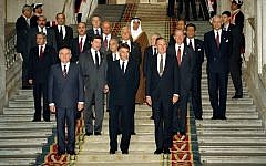 From left front, Soviet President Mikhail Gorbachev, Spanish Premier Felipe Gonzales and US President George H.W. Bush pose in front of delegates at the end of the first session of the Middle East peace conference held in the Palacio Real in Madrid, Spain, on October 30, 1991. (AP Photo/Jerome Delay)