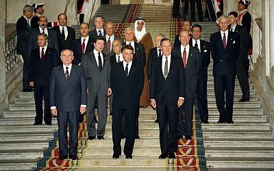 From left front, Soviet President Mikhail Gorbachev, Spanish Premier Felipe Gonzales and US President George H.W. Bush pose in front of delegates at the end of the first session of the Middle East peace conference held in the Palacio Real in Madrid, Spain, on October 30, 1991. (AP Photo/Jerome Delay)