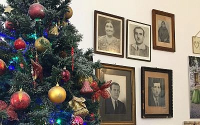 The Christmas tree in Beit Rima, next to photos of the Khoury family. (Federico Maccioni/ Times of Israel)