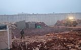 Israeli troops operate next to the entrance point to attack tunnel from southern Lebanon into an apple orchard south of the town of Metulla in northern Israel that Israel says was dug by the Hezbollah terror group on December 19, 2018. (Judah Ari Gross/Times of Israel)