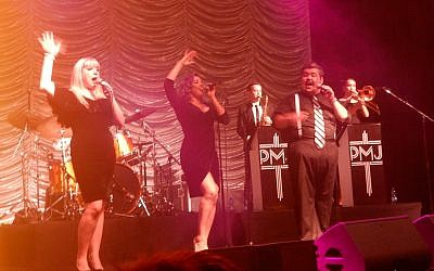 Postmodern Jukebox vocalists, from left, Joey Cook, Brittnie Price, and MC Mario Jose at the show in Tel Aviv on December 16, 2018. (Melanie Lidman/Times of Israel)