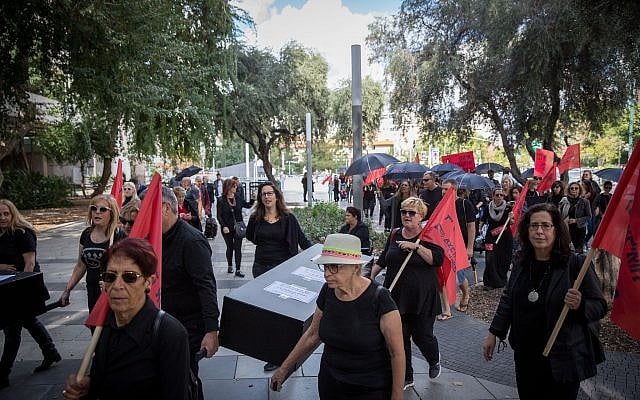 Israeli women hold fake coffins symbolizing the murders of women killed as part of a nationwide strike protesting the violence against women, Tel Aviv, December 4, 2018 (Miriam Alster/Flash90)