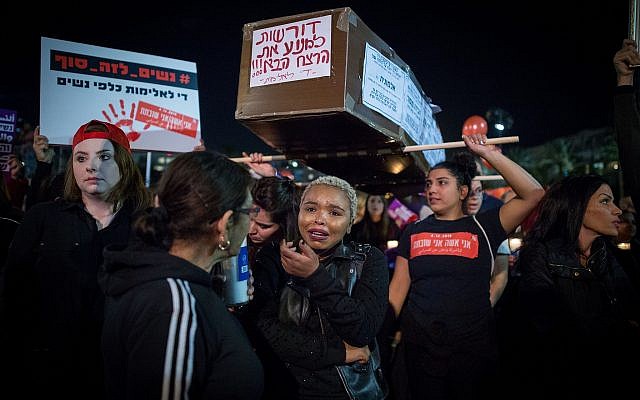 Protesters carry a fake coffin as thousands rally at Tel Aviv's Rabin Square as part of a nationwide strike demonstrating against the violence against women, December 4, 2018 (Miriam Alster/Flash90)
