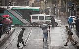 People walk on rain-soaked Jaffa Road in Jerusalem on December 6, 2018. (Yonatan Sindel/Flash90)