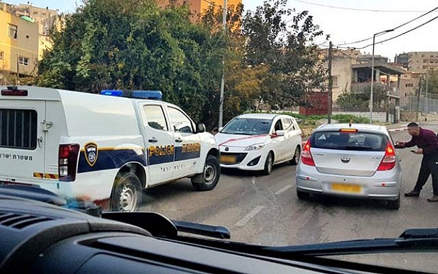 Illustrative: The scene of a drive-by shooting in the Arab Israeli town of Umm al-Fahm that left a 14-year-old boy wounded on December 26, 2018. The white car in the center was the target of the shooting, police said. (Hadashot TV screen capture) Illustrative: The scene of a drive-by shooting in the Arab Israeli town of Umm al-Fahm that left a 14-year-old boy wounded on December 26, 2018. The white car in the center was the target of the shooting, police said. (Hadashot TV screen capture)