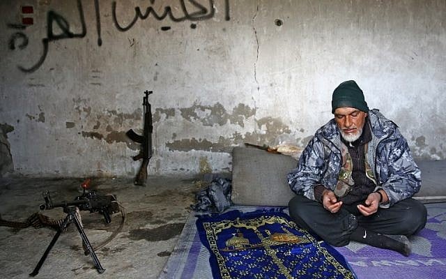 A Turkey-backed Syrian fighter recites a prayer in the town of Qirata, near the rebel-held border town of Jarabulus, on December 24, 2018. (Nazeer AL-KHATIB / AFP) A Turkey-backed Syrian fighter recites a prayer in the town of Qirata, near the rebel-held border town of Jarabulus, on December 24, 2018. (Nazeer AL-KHATIB / AFP)