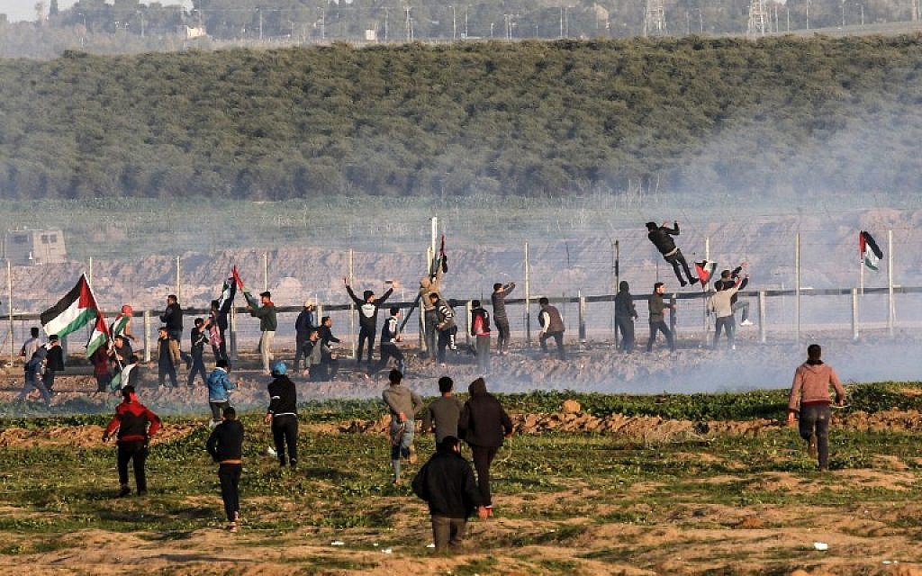 Palestinian protesters try to climb the border fence with Israel during clashes following a demonstration along the border east of Gaza City on January 4, 2019. (Said Khatib/AFP)