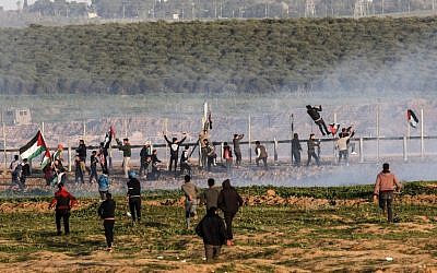 Palestinian protesters try to climb the border fence with Israel during clashes following a demonstration along the border east of Gaza City on January 4, 2019. (Said Khatib/AFP)