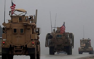 This file photo taken on December 30, 2018 shows a line of US military vehicles in Syria's northern city of Manbij (Delil Souleiman/AFP)