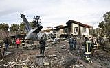 Firefighters and security forces gather amidst the debris of a Boeing 707 cargo plane that reportedly crashed into a residential complex near the Iranian capital Tehran with 10 people onboard on January 14, 2019. (HASAN SHIRVANI/various sources/AFP)