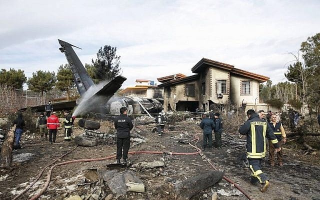 Firefighters and security forces gather amidst the debris of a Boeing 707 cargo plane that reportedly crashed into a residential complex near the Iranian capital Tehran with 10 people onboard on January 14, 2019. (HASAN SHIRVANI/various sources/AFP) Firefighters and security forces gather amidst the debris of a Boeing 707 cargo plane that reportedly crashed into a residential complex near the Iranian capital Tehran with 10 people onboard on January 14, 2019. (HASAN SHIRVANI/various sources/AFP)