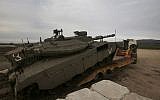 An Israeli army Merkava tank is loaded into a truck in the Golan Heights, on January 20, 2019. ( JALAA MAREY / AFP)
