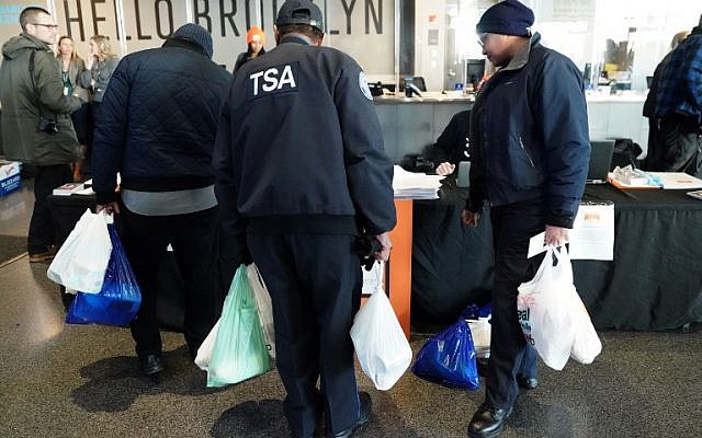 Furloughed Transportation Security Administration (TSA) employees and others leave the Barclays Center with bags of food as the Food Bank For NYC holds food distribution for federal workers impacted by the government shutdown in Brooklyn, New York January 22, 2019. ( TIMOTHY A. CLARY / AFP)