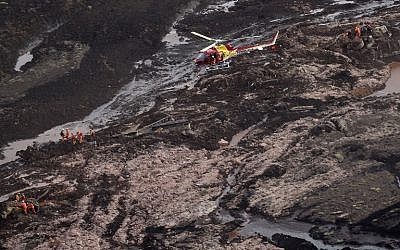 Aerial view showing firemen looking for people in heavy machinery (L and R) and a locomotive (C) after the collapse of a dam near the town of Brumadinho in southeastern Brazil, on January 25, 2019. (Douglas Magno / AFP)