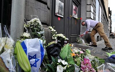 File: A man lays flowers as he pays his respects in front of a makeshift memorial at the entrance of the Jewish Museum in Brussels, where a deadly shooting took place the day before, killing four, May 25, 2014 (Georges Gobet/AFP) File: A man lays flowers as he pays his respects in front of a makeshift memorial at the entrance of the Jewish Museum in Brussels, where a deadly shooting took place the day before, killing four, May 25, 2014 (Georges Gobet/AFP)
