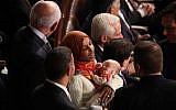 Representative-elect Ilhan Omar (D-Minnesota) holds a baby while talking to fellow members of Congress during the first session of the 116th Congress at the US Capitol on January 3, 2019 in Washington, DC. (Mark Wilson/Getty Images/AFP)