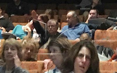 In this Nov. 2, 2018, photo, Housatonic Community College business professor Charles Meyrick, top left, raises his right arm during a faculty and administrators' meeting in Manchester, Conn. The community college fired the professor, Meyrick, Thursday, Jan. 24, 2019, who was accused of comparing education officials to Nazis by shouting in German and giving a Nazi salute for more than 10 minutes at the meeting. (AP Photo)