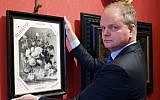 In this photo made available on January 1, 2019, Eike Schmidt, director of the Uffizi Gallery, poses for a photo as he holds onto a copy of a still-life "Vase of Flowers," by Dutch artist Jan van Huysum, with writing in red reading "stolen," inside the Uffizi gallery, in Florence, Italy. (Uffizi Gallery press office via AP)
