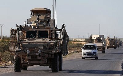 A convoy of US troops drive along a road leading to the front line with Turkish-backed fighters in north Syria, March 31, 2018. (AP Photo/Hussein Malla, File)
