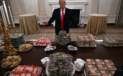 US President Donald Trump talks to the media about the table full of fast food in the State Dining Room of the White House in Washington, January 14, 2019, for the reception for the Clemson Tigers. (AP Photo/Susan Walsh)