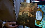 Pastor of the Sint-Ludgeruskerk, Jan Van Raemdonck holds a photo copy of the work Madonna del Silenzio in his office in Zele, Belgium, Tuesday, Jan. 15, 2019. (AP/Virginia Mayo)