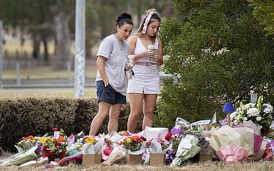 Two women stand at a floral tribute on January 18, 2019, at the scene where the body of Israeli student Aiia Maasarwe was found earlier in the week in Melbourne, Australia. (Ellen Smith/AAP Image via AP)