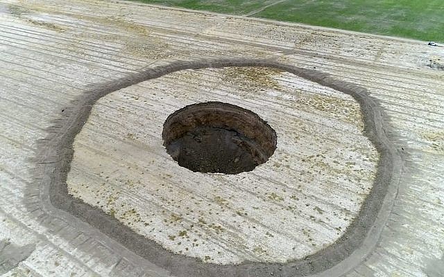 This frame grab from an August 8, 2018, video provided by Iranian Students' News Agency, ISNA, shows an aerial view of a massive hole caused by drought and excessive water pumping in Kabudarahang, in Hamadan province, in western Iran. (ISNA via AP) This frame grab from an August 8, 2018, video provided by Iranian Students' News Agency, ISNA, shows an aerial view of a massive hole caused by drought and excessive water pumping in Kabudarahang, in Hamadan province, in western Iran. (ISNA via AP)
