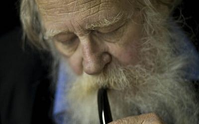 In this file photo taken on Nov. 10, 2010, Rabbi Adin Steinsaltz smokes a pipe during an interview with The Associated Press in Jerusalem. The 73-year-old rabbinical scholar had just completed a monumental 45-year project hailed in Jewish scholarly circles as a breakthrough of biblical proportions, the most comprehensive translation and commentary of the Talmud, with its 63 basic sections and nearly 6,000 pages. (AP Photo/Bernat Armangue, File)