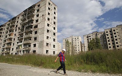 Illustrative: An Abkhazian man walks past war-damaged apartment buildings in Sukhumi, the capital of the Georgian breakaway region of Abkhazia, on August 25, 2011. (AP Photo/Mikhail Metzel)