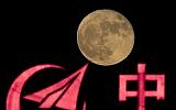 In this photo taken Tuesday, Nov. 15, 2016, the supermoon rises over a logo for AVIC, or Aviation Industry Corp, a state owned enterprise involved in China's manned space mission in Beijing. (AP Photo/Ng Han Guan)