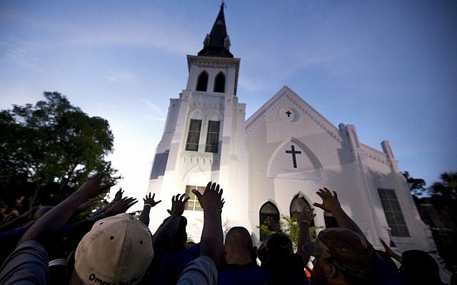 In this Friday, June 19, 2015 file photo a crowd of people pray outside the Emanuel AME Church, after a memorial for the nine people killed by Dylann Roof in Charleston, S.C. .(AP Photo/Stephen B. Morton) In this Friday, June 19, 2015 file photo a crowd of people pray outside the Emanuel AME Church, after a memorial for the nine people killed by Dylann Roof in Charleston, S.C. .(AP Photo/Stephen B. Morton)