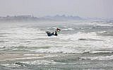 Illustrative: A fisherman navigates rough seas along the coast of the Mediterranean Sea in Gaza City, April 11, 2018. (Adel Hana/AP)