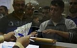 Hamas government employees wait to receive 60 percent of their long-overdue salaries, at the main Gaza Post Office, in Gaza City, November 9, 2018. (AP Photo/Adel Hana)