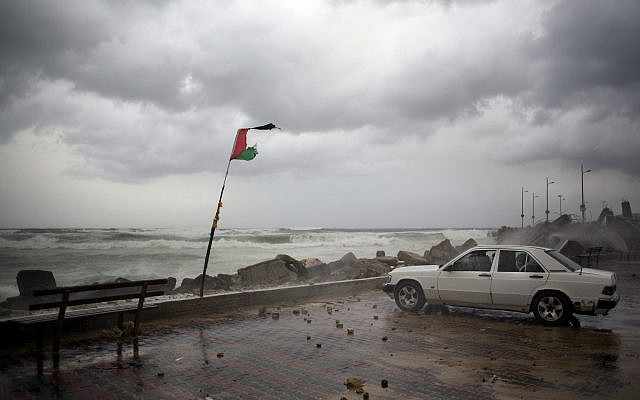 A Palestinian family sits inside their car on the Mediterranean seaside during a rain storm in Gaza City, Wednesday, Jan. 16, 2019. (AP Photo/Khalil Hamra)