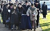 A group of Holocaust survivors transport a covered coffin with the remains of six unidentified Holocaust victims to be buried at the United Synagogue's New Cemetery in Bushey, England, January 20, 2019. (John Stillwell/PA via AP)