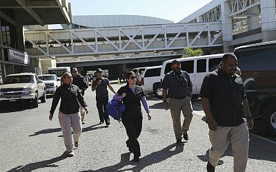 United States embassy security agents walk after dropping off US embassy employees and their families at the Simon Bolivar international airport in La Guaira, Venezuela, Friday, Jan. 25, 2018. (AP/Rodrigo Abd)