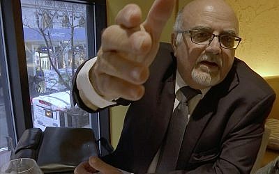 A man who identified himself as Michel Lambert but whose real name is Aharon Almog Assoulin and was linked in investigations by Channel 12's Uvda program and AP with an alleged undercover operation targeting critics of the Israeli tech firm NSO Group, seen in a screen capture from AP video footage. (AP Photo/Joseph Frederick)