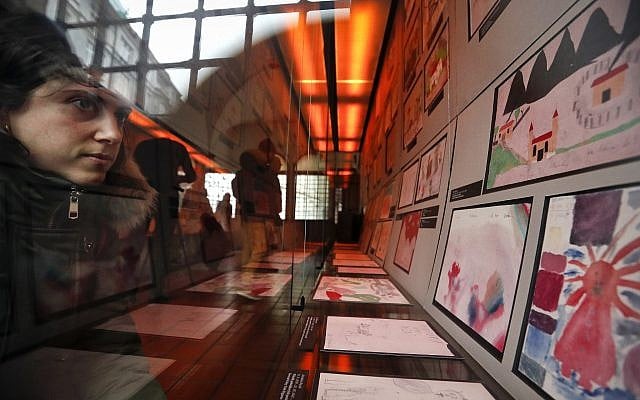 A visitor looks at the collection of drawings at the Jewish Museum in Prague, Czech Republic, Jan. 24, 2019, made by Jewish children who passed through the Terezin Ghetto during WWII (AP Photo/Petr David Josek)