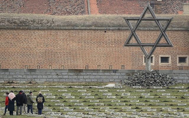 Visitors walk through the cemetery of the former Nazi concentration camp in Terezin, Czech Republic, Jan. 24, 2019  (AP Photo/Petr David Josek)
