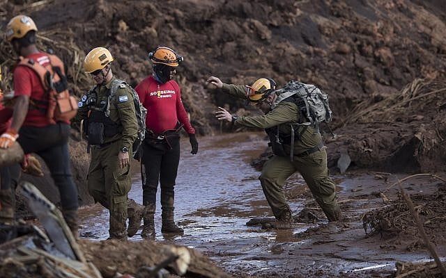 An Israeli rescue specialist, right, arrives at a site where a body was found inside a vehicle stuck in the mud, days after a dam collapse in Brumadinho, Brazil, Monday, Jan. 28, 2019. Firefighters on Monday carefully moved over treacherous mud, sometimes walking, sometimes crawling, in search of survivors or bodies four days after a dam collapse that buried mine buildings and surrounding neighborhoods with iron ore waste. (AP Photo/Leo Correa) An Israeli rescue specialist, right, arrives at a site where a body was found inside a vehicle stuck in the mud, days after a dam collapse in Brumadinho, Brazil, Monday, Jan. 28, 2019. Firefighters on Monday carefully moved over treacherous mud, sometimes walking, sometimes crawling, in search of survivors or bodies four days after a dam collapse that buried mine buildings and surrounding neighborhoods with iron ore waste. (AP Photo/Leo Correa)