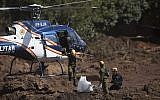 Israeli rescue specialists arrive at a site where a body was found inside a vehicle stuck in the mud, days after a dam collapse in Brumadinho, Brazil, on January 28, 2019. (AP Photo/Leo Correa)