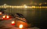 Candles burn in front of the cast iron shoes at the Holocaust Memorial on the quay of the River Danube, during International Holocaust Remembrance Day in Budapest, Hungary, Wednesday, Jan. 27, 2016 (Balazs Mohai/MTI via AP)