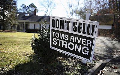 A sign saying, "Don't Sell! Toms River Strong," is seen on a street Monday, Feb. 22, 2016, in Toms River, N.J. A housing crunch in the New Jersey shore town that’s home to one of the nation’s largest Hasidic populations has neighboring towns changing their own laws. Real estate agents and investors in the Lakewood area have been soliciting residents in several nearby neighborhoods, looking to find homes that fit the needs of the growing Jewish community. (AP Photo/Mel Evans)