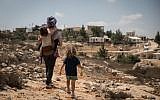 Illustrative: A woman takes her children on a walk in  the Jewish settlement of Sde Boaz in Gush Etzion, West Bank, on August 28, 2018. (Hadas Parush/Flash90)