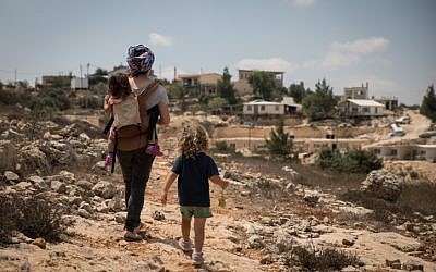 Illustrative: A woman takes her children on a walk in  the Jewish settlement of Sde Boaz in Gush Etzion, West Bank, on August 28, 2018. (Hadas Parush/Flash90)