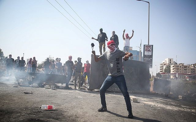 Palestinian demonstrators clash with Israeli troops during clashes near the settlement of Beit El on October 2, 2018. (Flash90) Palestinian demonstrators clash with Israeli troops during clashes near the settlement of Beit El on October 2, 2018. (Flash90)