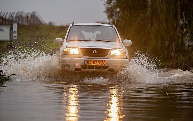 A vehicle crosses a flooded stream on the Golan Heights, January 14, 2019. (Maor Kinsbursky/Flash90)