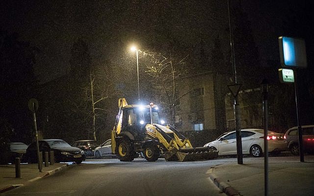 A tractor clears snow from a road as snow falls in the Old Katamon neighborhood in Jerusalem, on January 16, 2019. (Hadas Parush/Flash90) A tractor clears snow from a road as snow falls in the Old Katamon neighborhood in Jerusalem, on January 16, 2019. (Hadas Parush/Flash90)